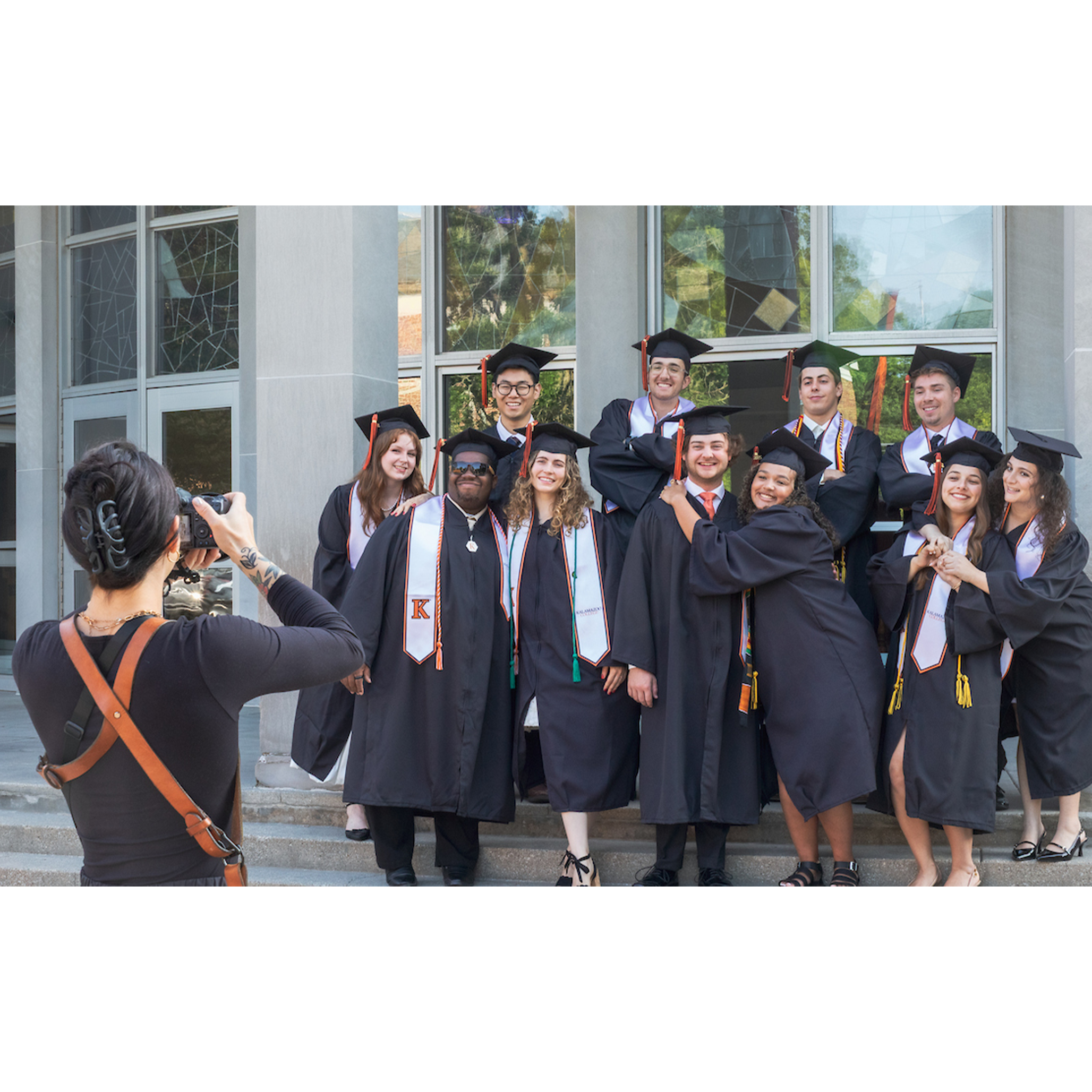 A group of graduates being photographed at Light Fine Arts steps.
